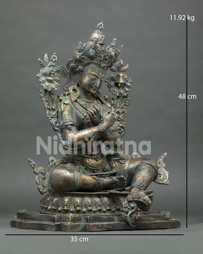 Right side view of bronze Vajradhara statue with lotus, vajra, and bell details