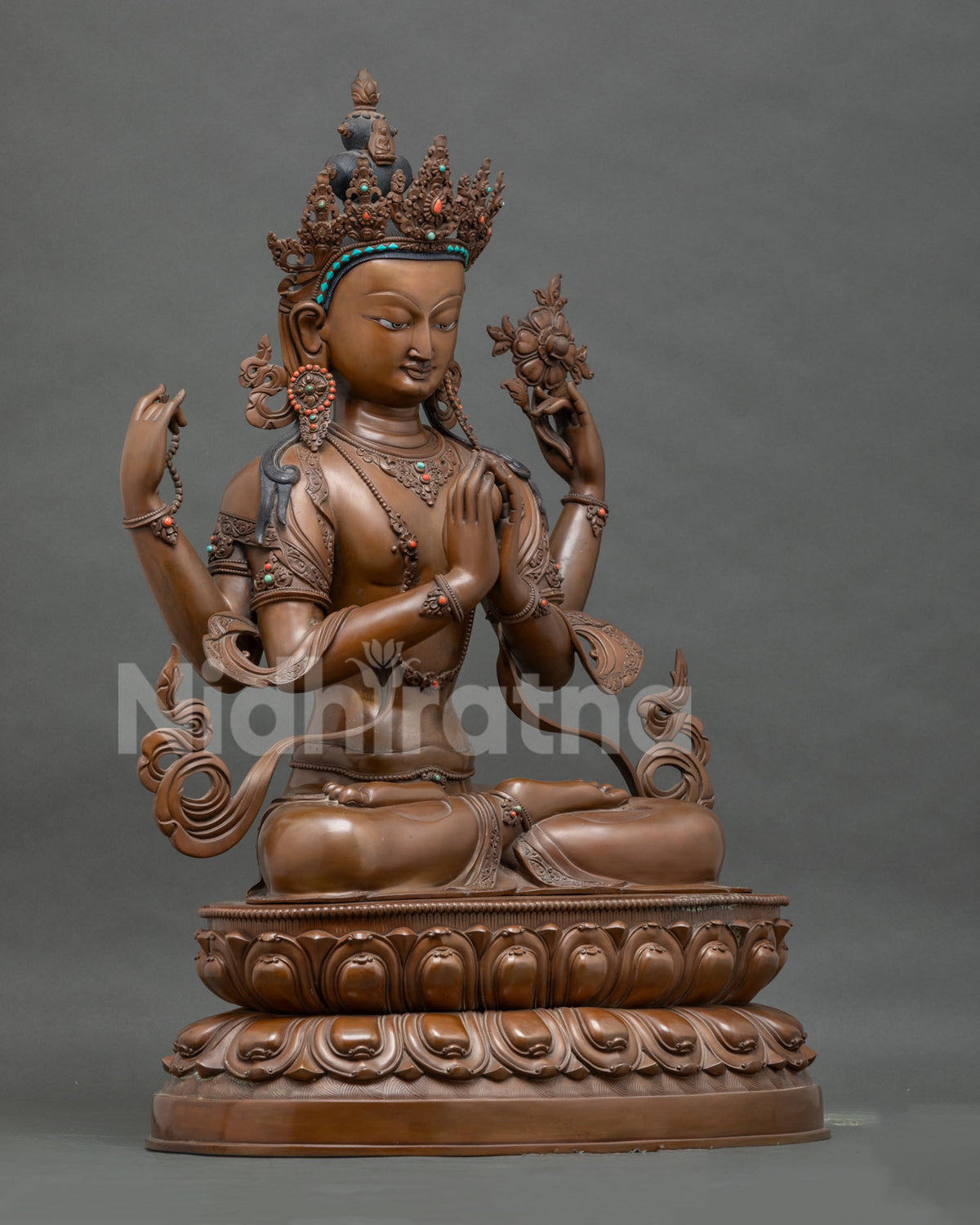 Right side view of Chenrezig statue showing crown, ornaments, and lotus stem