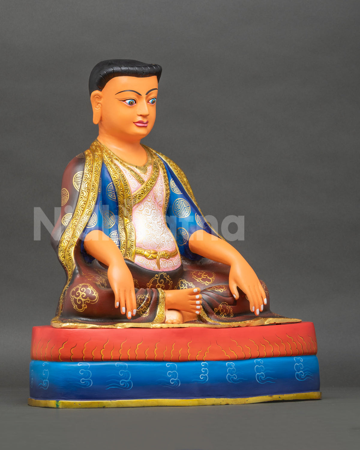right side view of copper marpa lotsawa statue seated in meditation on a double pedestal