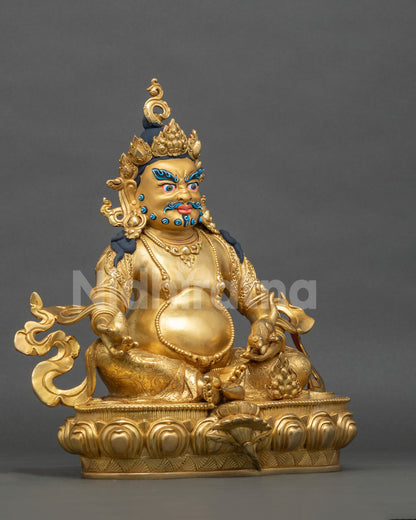Right side view of gold gilded Dzambhala copper statue holding a citron on a carved lotus base