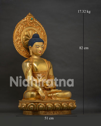 Right side view of gold gilded Shakyamuni Buddha statue with ornamental halo and lotus base