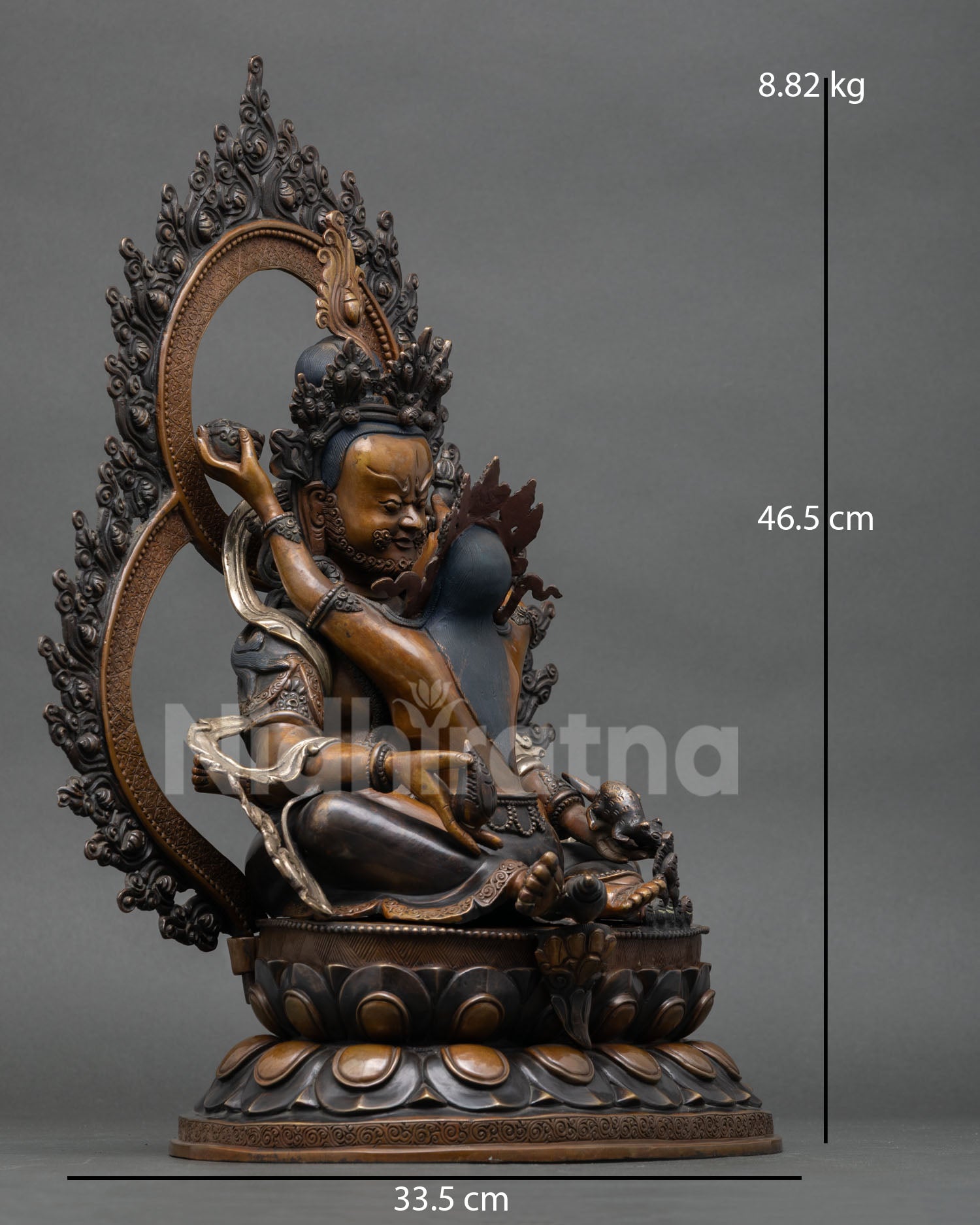 right side view of green dzambhala prosperity deity statue with flaming prabhavali halo