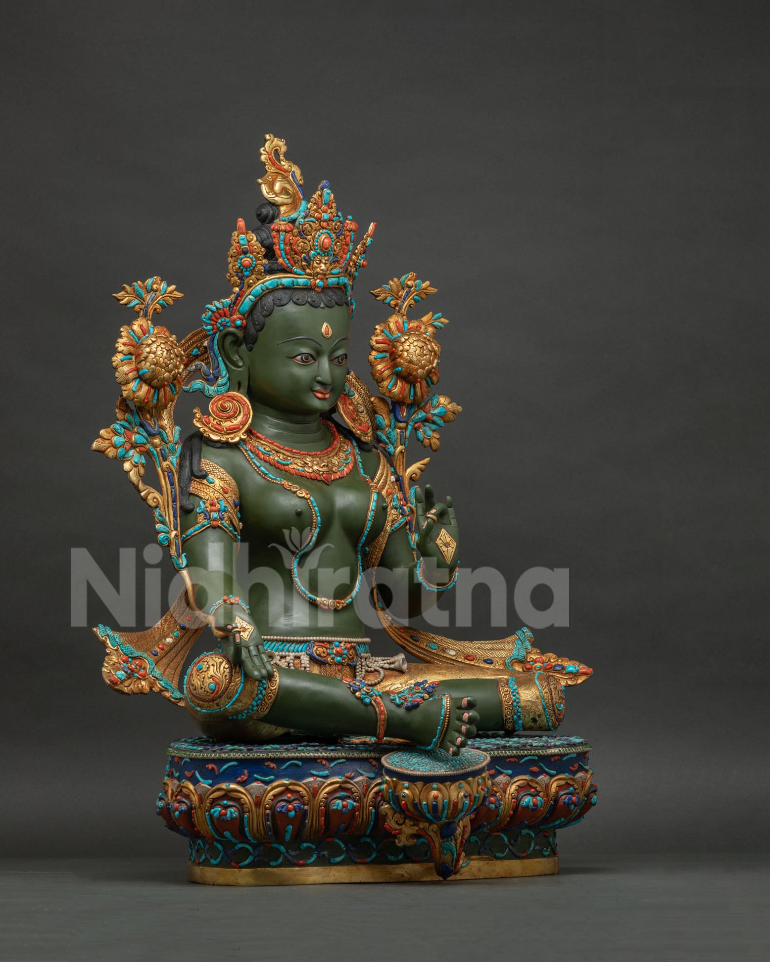 Right side view of Green Tara statue in Lalitasana posture with blooming lotus flower and gold gilding.