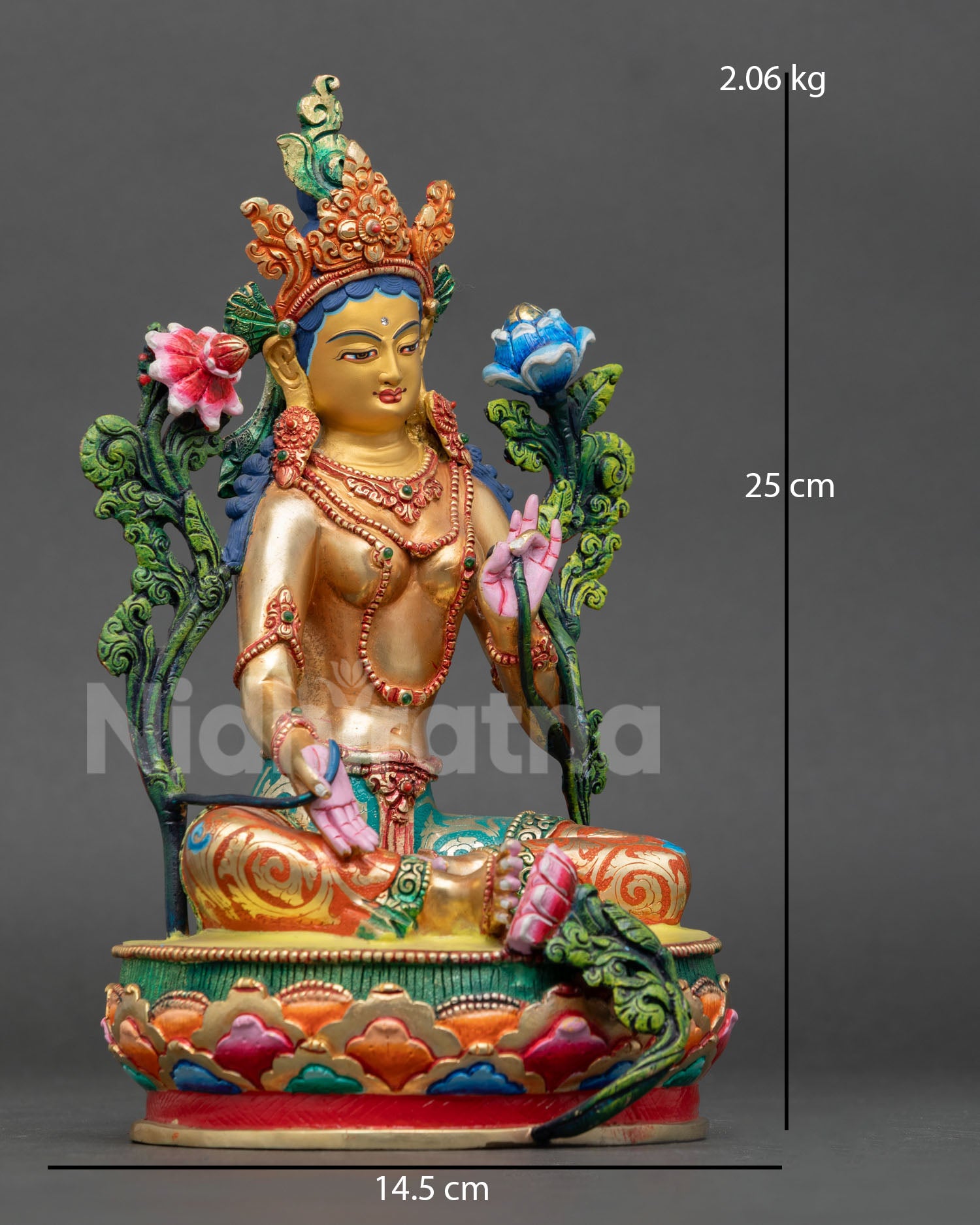 right side view of green tara statue, traditional nepalese copper sculpture seated on lotus pedestal