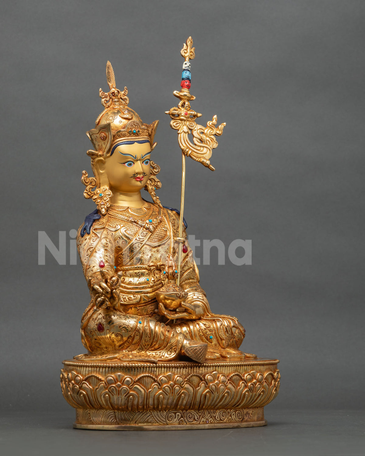 Right side view of Guru Rinpoche statue with khatvanga staff and lotus base
