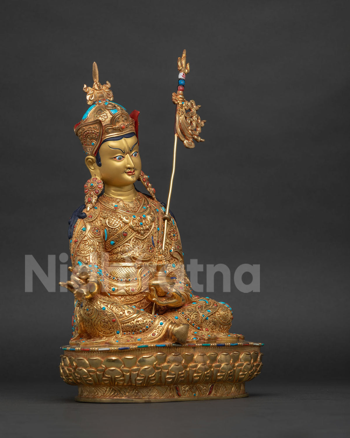 Right side view of hand-carved copper Guru Rinpoche statue on lotus pedestal