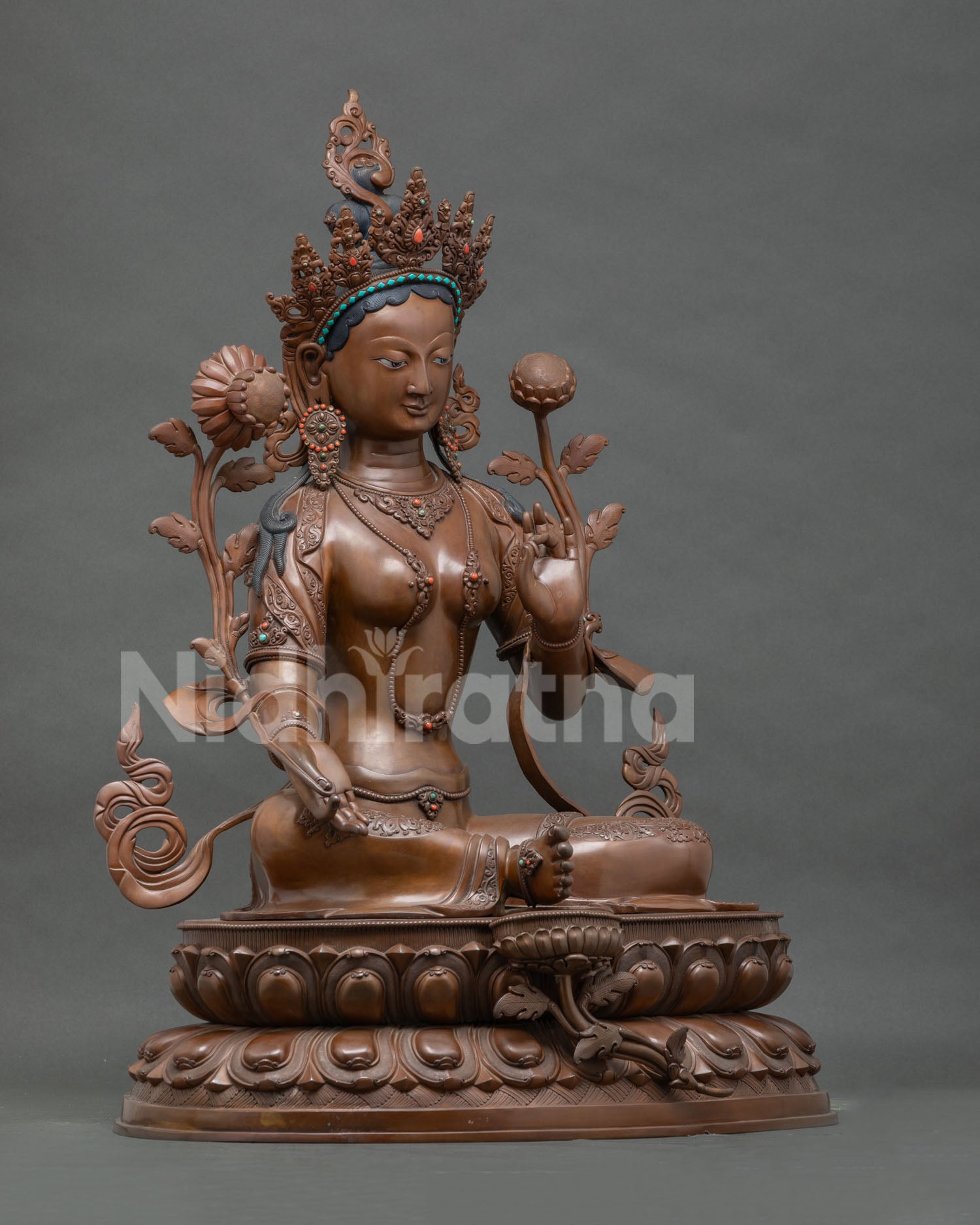 Right side view of large oxidized copper Green Tara statue on lotus seat