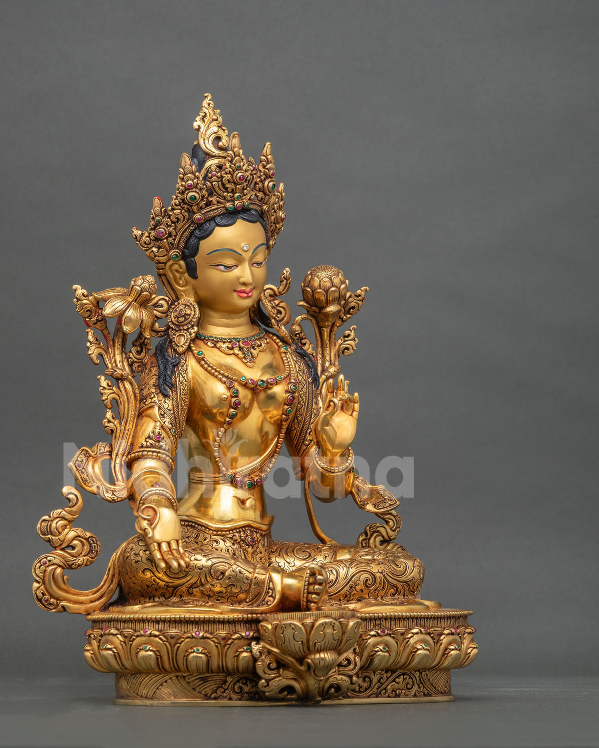 Right side view of Nepalese Green Tara statue seated on a lotus base with gilded details