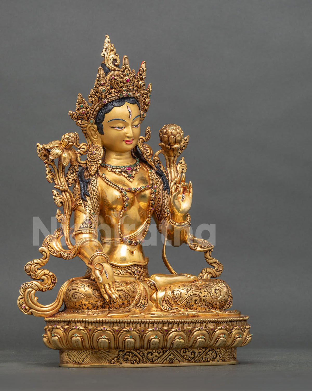 Right side view of Nepalese White Tara statue seated on a lotus base with gilded details