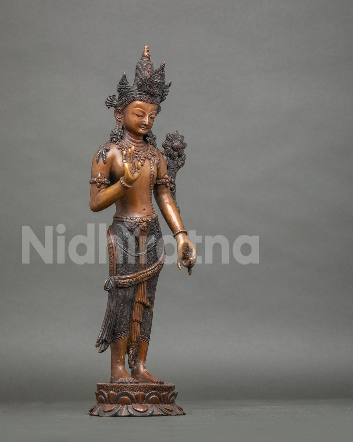 Right side view of oxidized copper Lokeshvara statue with flowing drapery and lotus pedestal