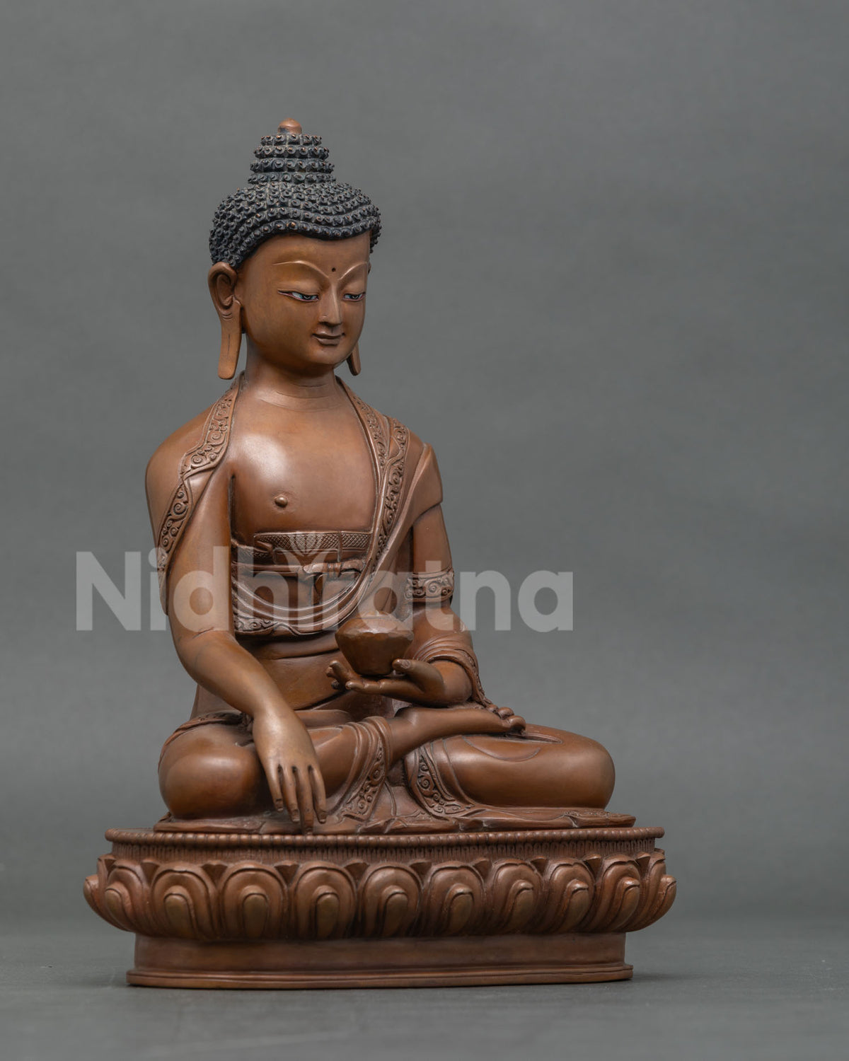 Right side view of oxidized copper Shakyamuni Buddha statue seated on a lotus base