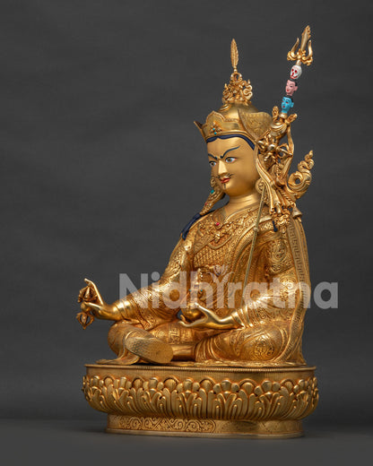 Right side view of Padmasambhava statue highlighting raised five-pointed vajra and layered robes.