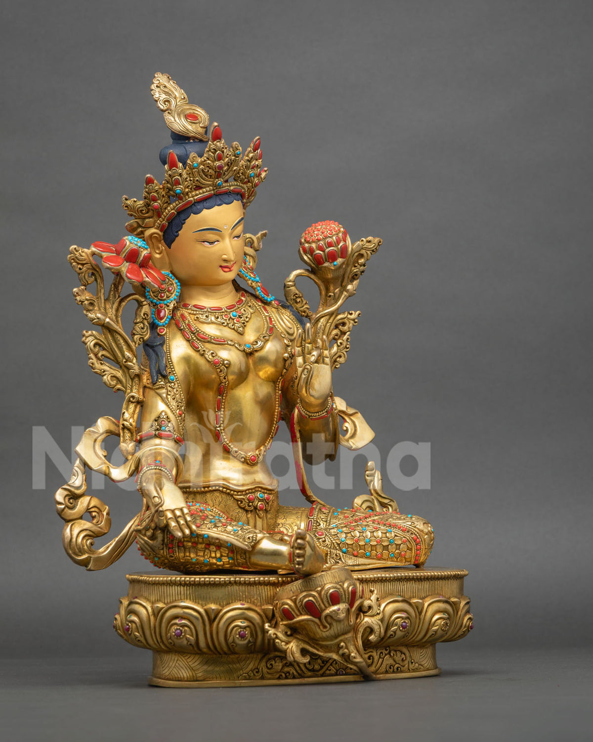 Right side view of seated Green Tara statue with extended leg and lotus stems on gold lotus throne