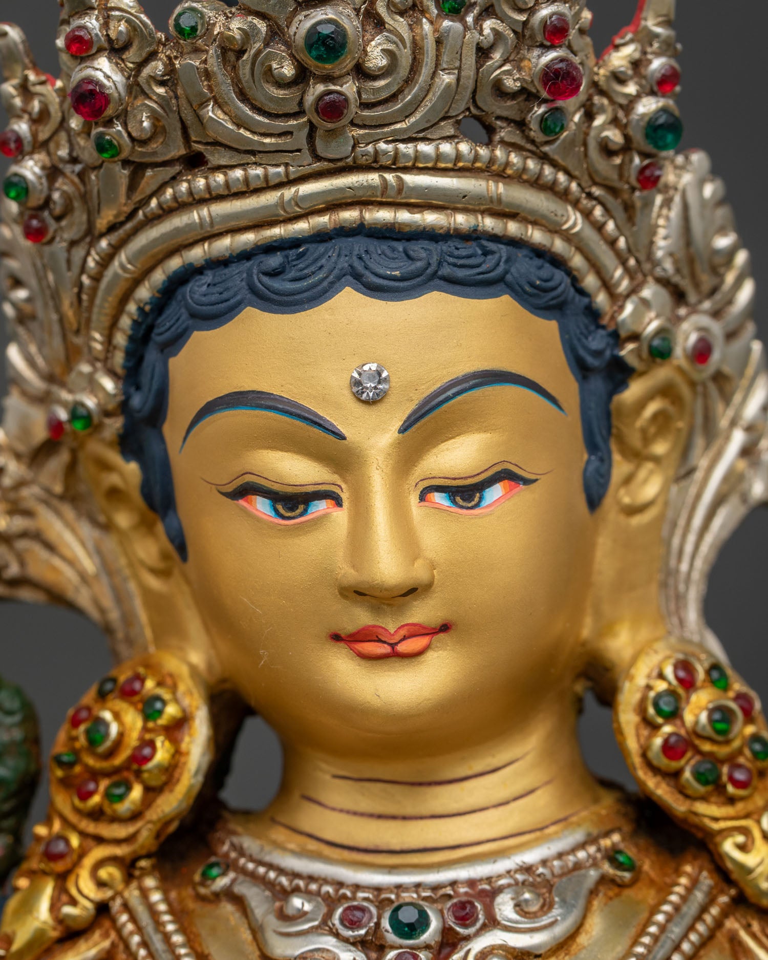 detailed close up face of green tara statue 24k gold painted