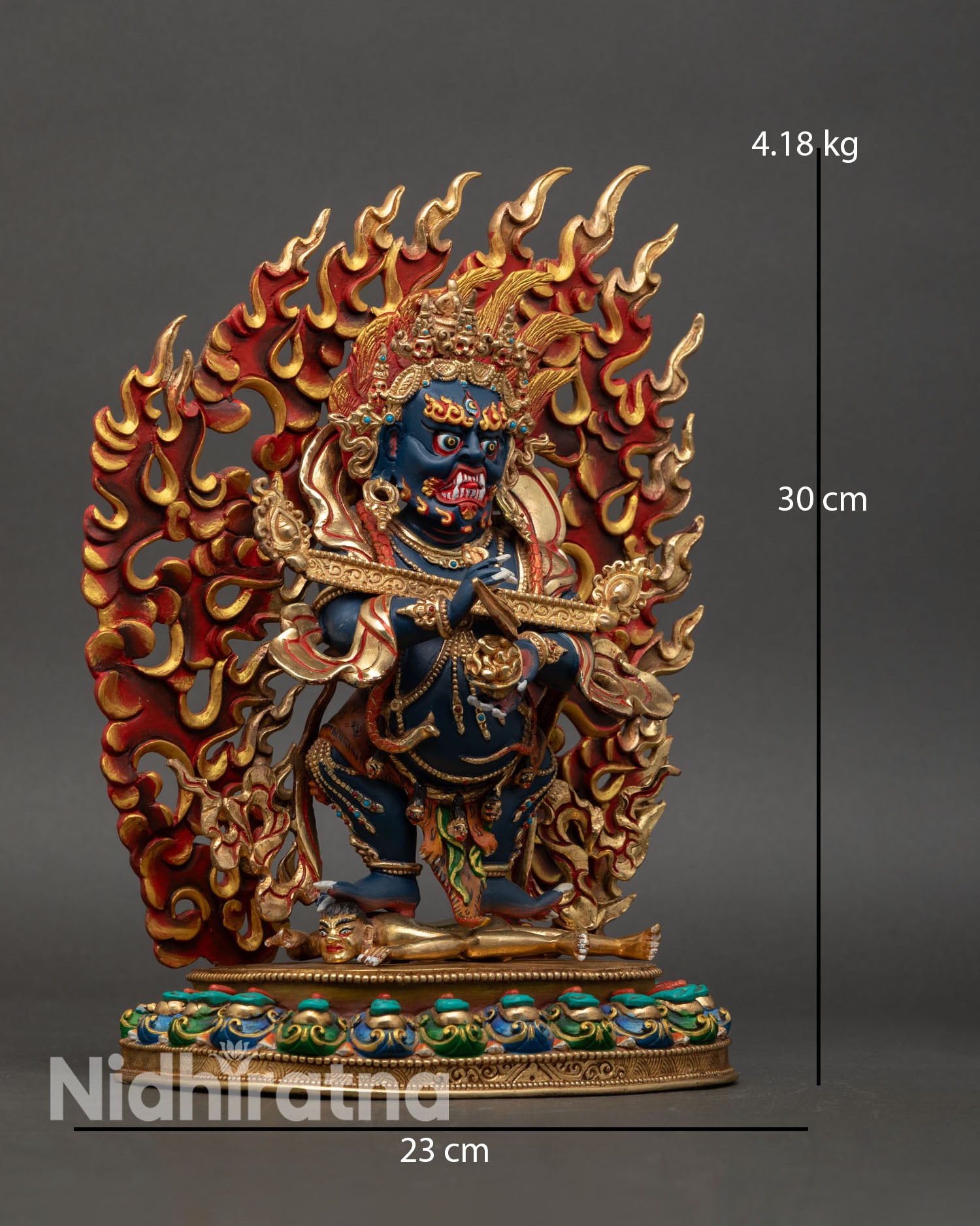 Sakya Mahakala dynamic posture shown subduing figure on lotus seat with flaming halo wrathful protector Buddhist sculpture from Nepal.