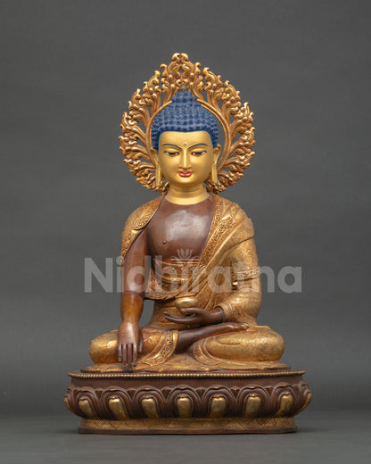 seated shakayamuni buddha statue in copper with oxidized finish and gold gilded robes on lotus pedestal