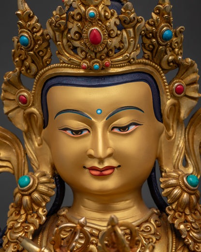 Serene face of gold-gilded Vajradhara statue with downcast eyes and gentle smile
