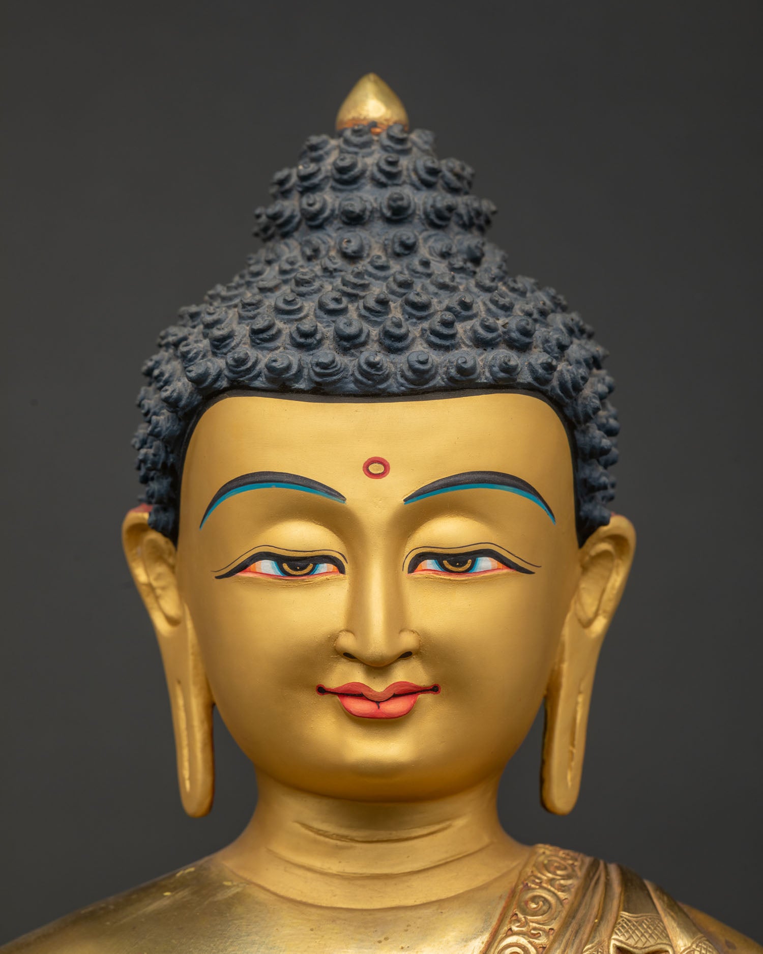 Serene golden face of Shakyamuni Buddha statue with blue hair details