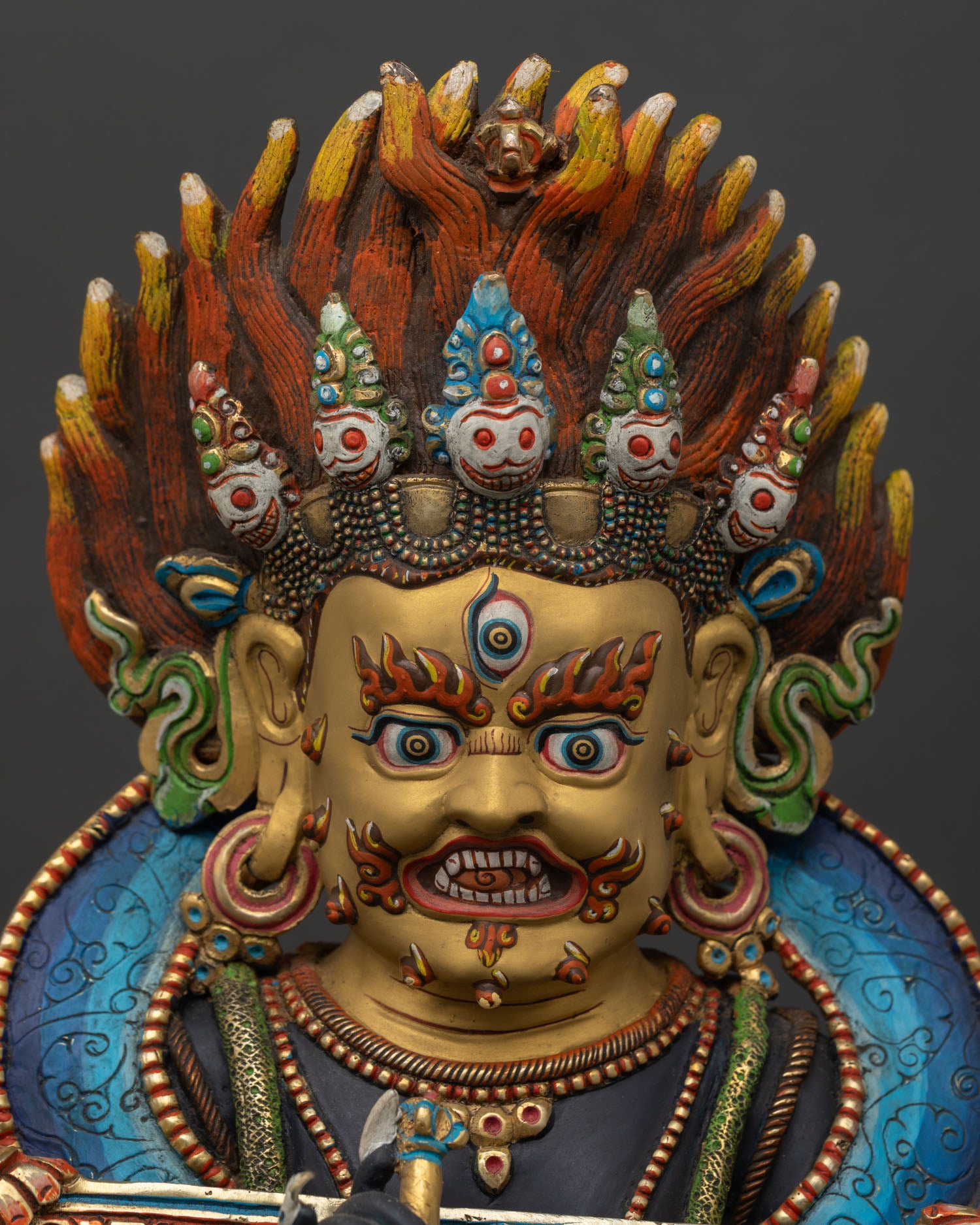 Shakya Mahakala close up fierce gold painted face with hand finished details wrathful Buddhist deity copper statue with gold gilded accents.
