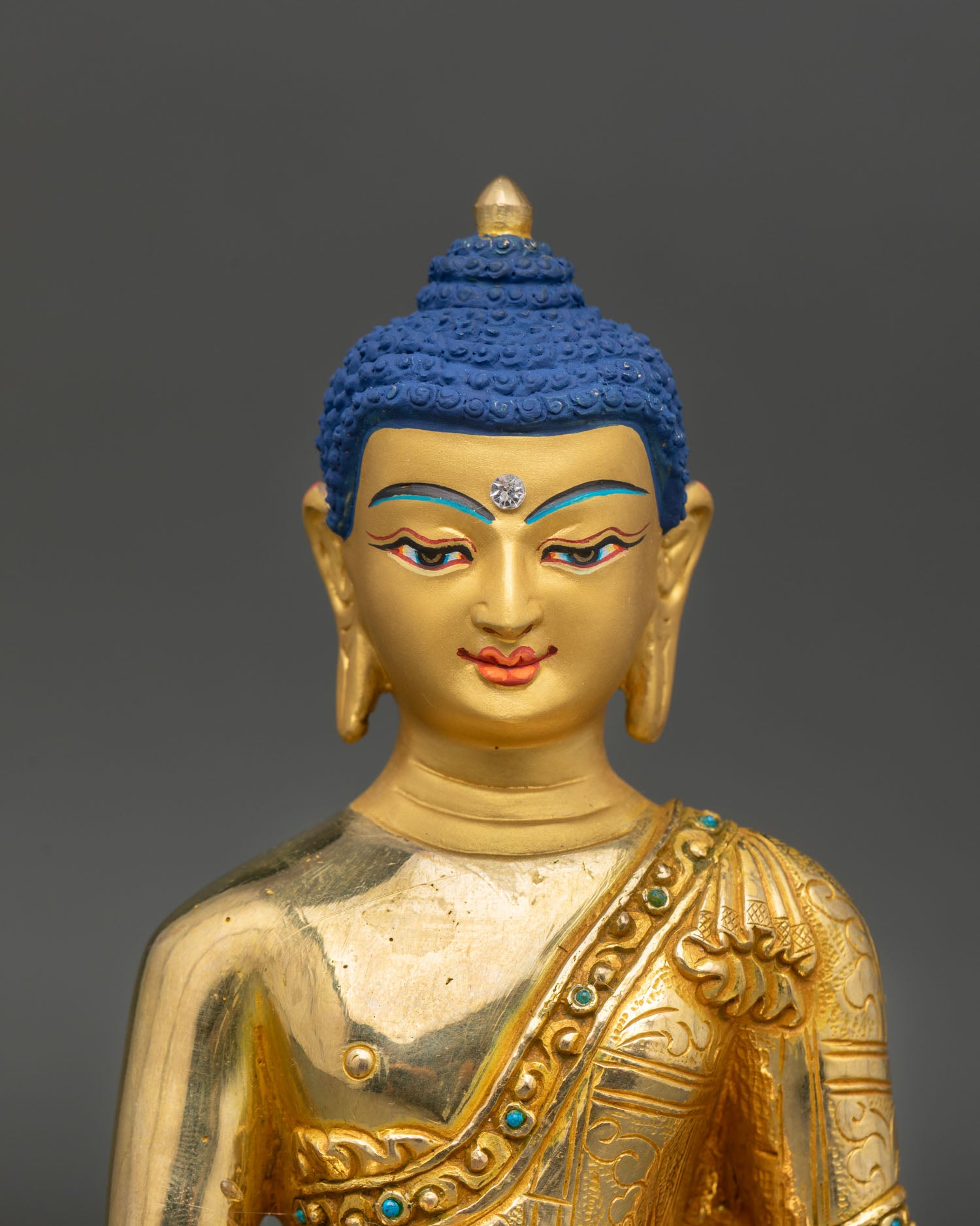 Shakyamuni Buddha close up gold painted face bodhi awakening detail lost wax buddhist art patan nepal