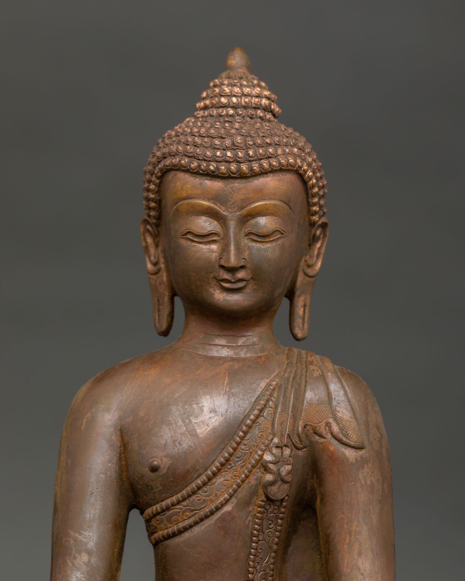 Shakyamuni Buddha face close up with detailed handcarved monk robe from Nepal.