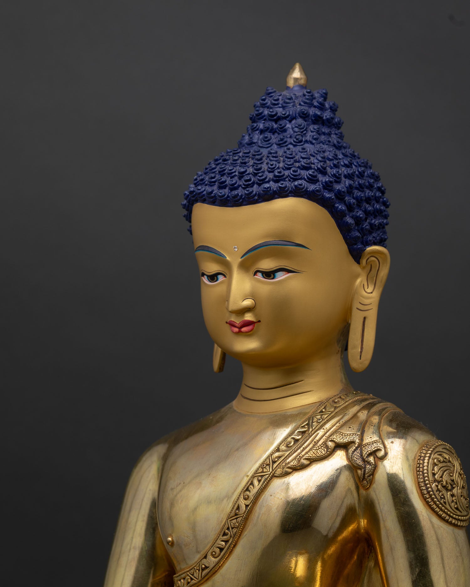 Shakyamuni Buddha profile face close-up gold tones serene expression copper statue Nepal