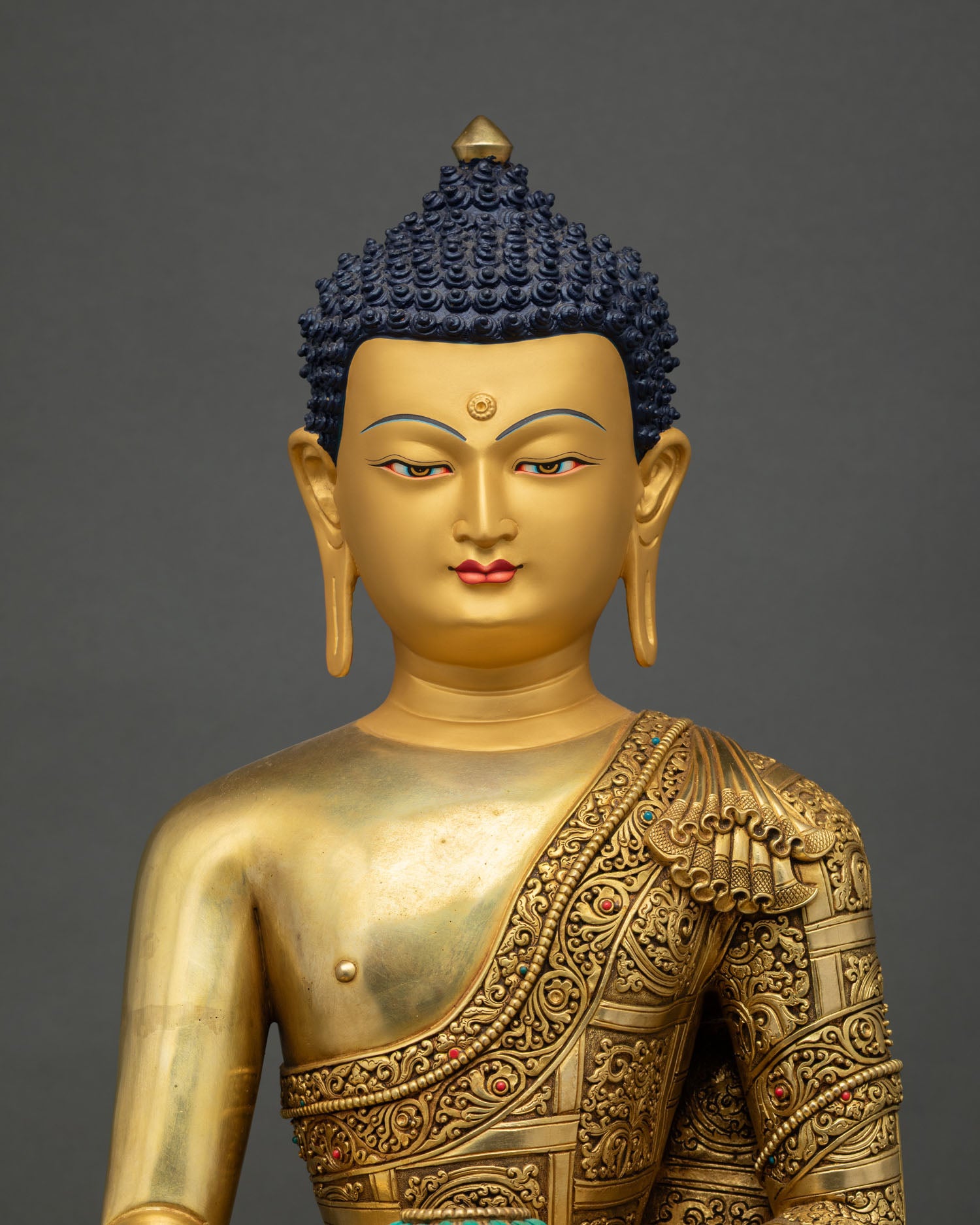 Shakyamuni Buddha sculpture with gold-painted head, serene expression, blue curled hair detail