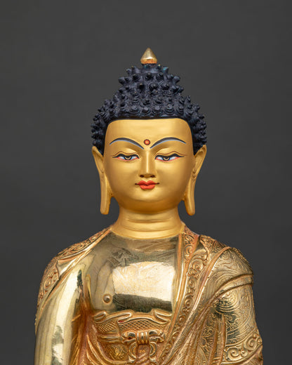 Shakyamuni Buddha statue 24k gold painted face close up.