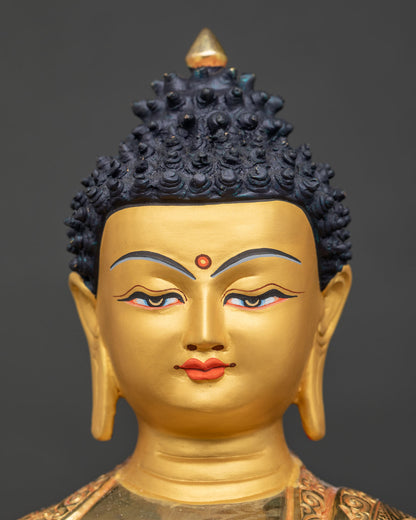 Shakyamuni Buddha statue 24k gold painted face detailed close up.