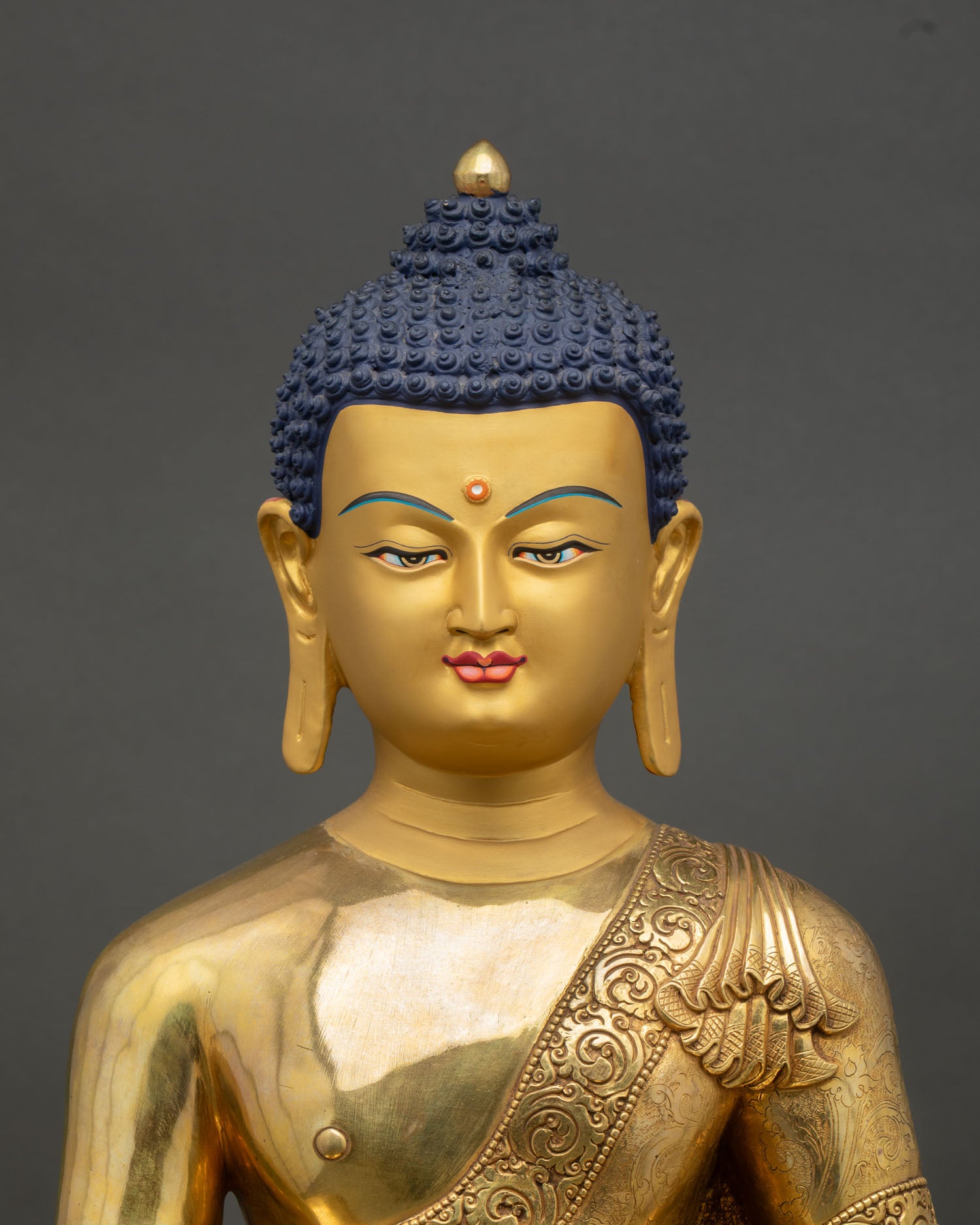 Close up Shakyamuni Buddha statue, handcrafted Nepal copper and gold artwork with intricate lost wax detailing