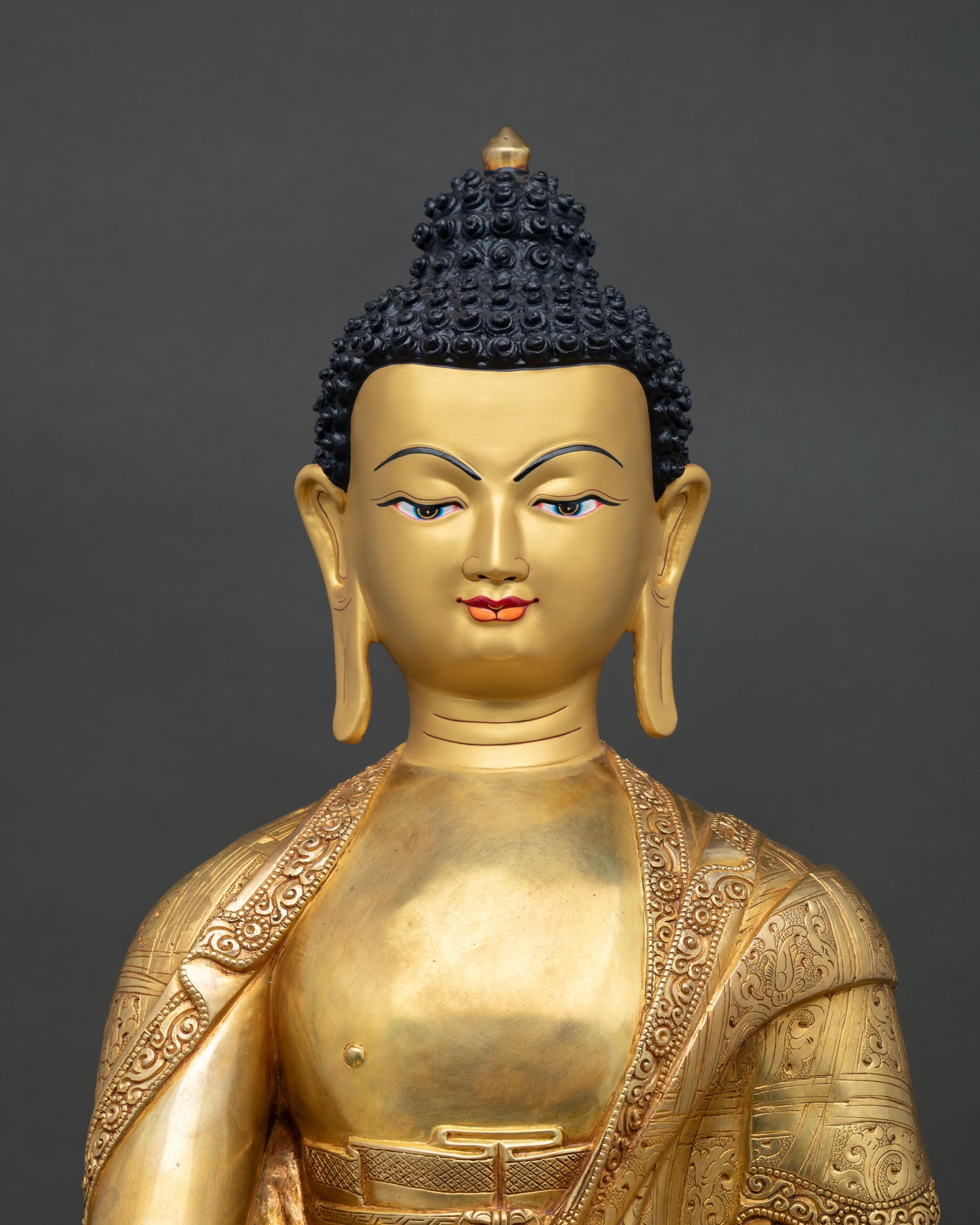 Shakyamuni Buddha statue close up showing gold gilded details and serene expression