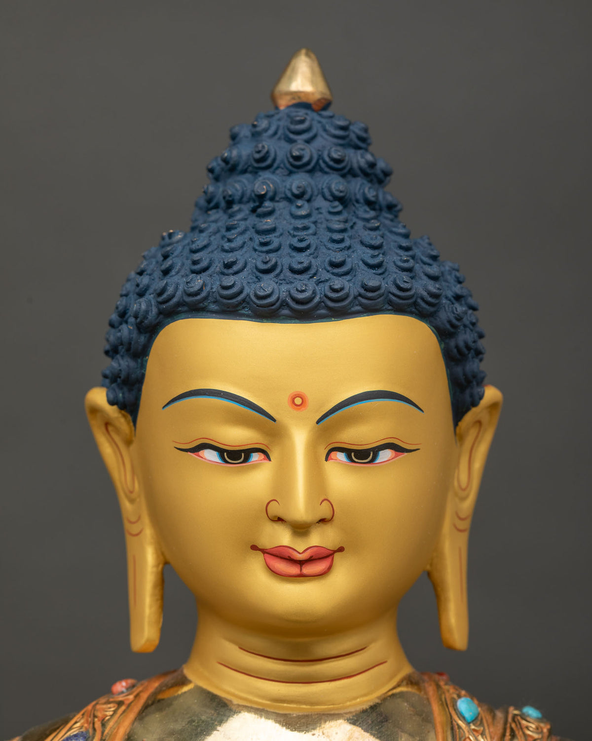 Shakyamuni Buddha statue deep blue eyes elongated ears face close up.