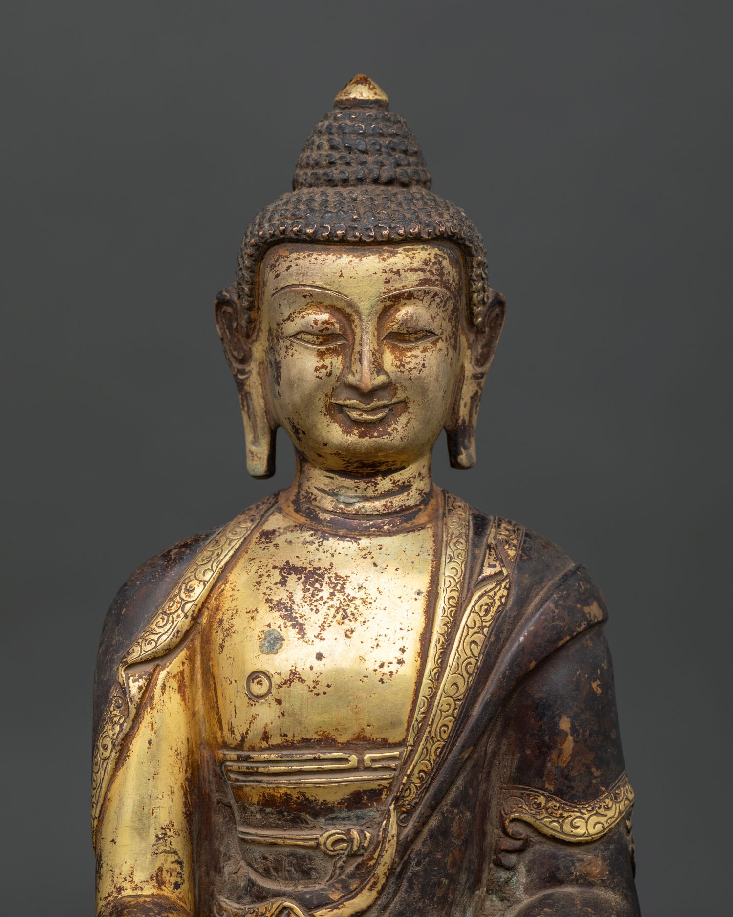 Shakyamuni Buddha statue detailed face with antique gold gilded finish.
