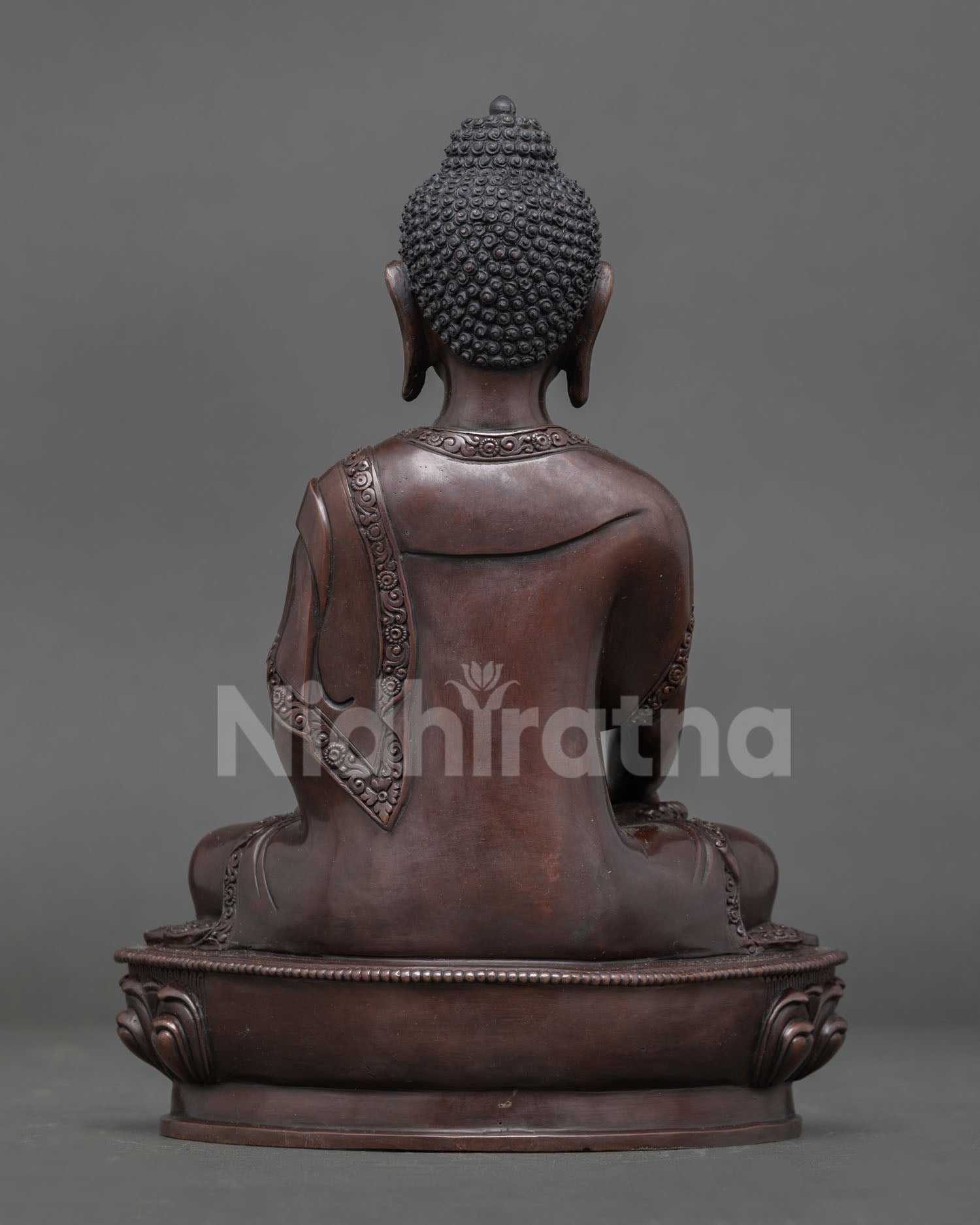 Shakyamuni buddha statue displaying intricate copper artwork and buddhist details.