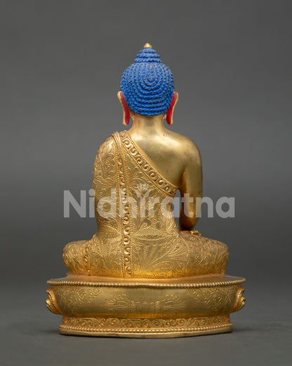 Shakyamuni buddha statue displaying intricate gold gilded artwork and nepalese craftsmanship.