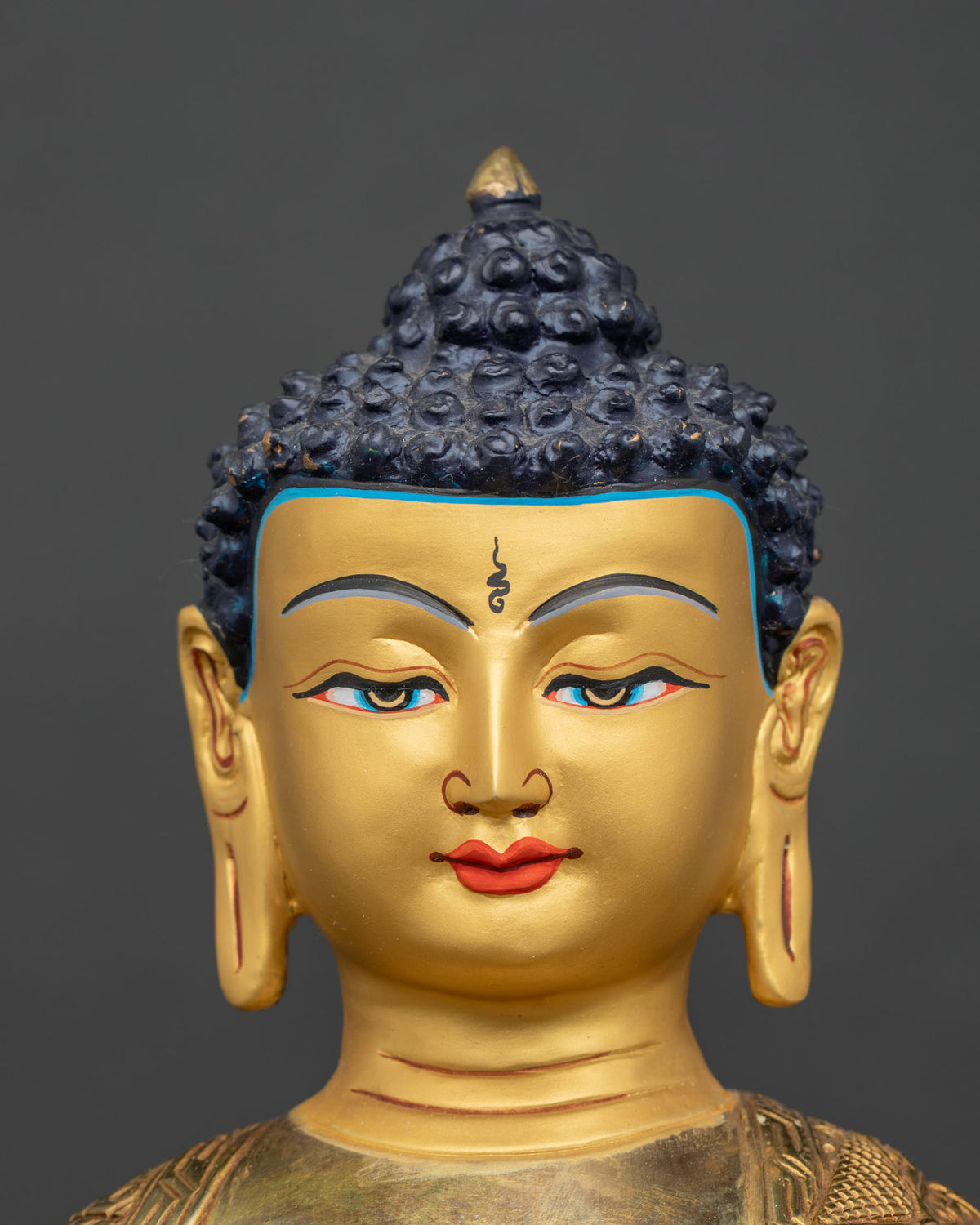 Shakyamuni Buddha statue face close up 24K gold painted face.