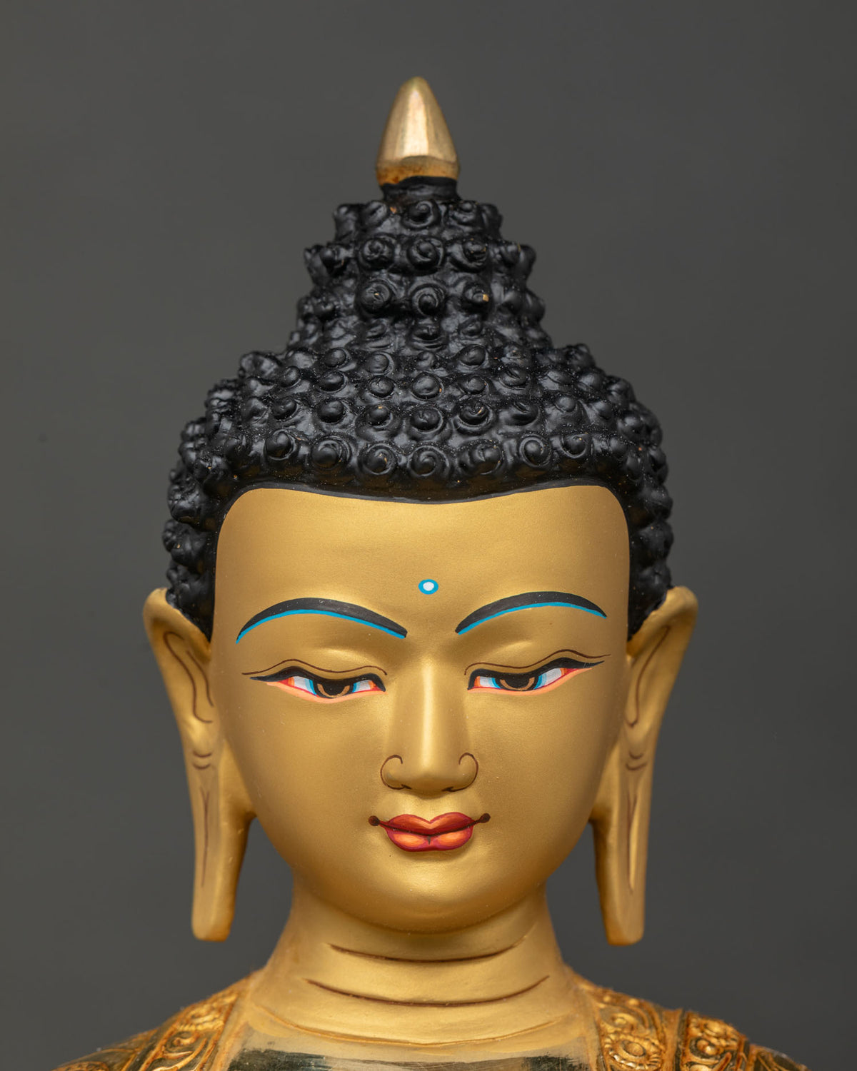 Shakyamuni Buddha statue face close up serene expression gold gilded.