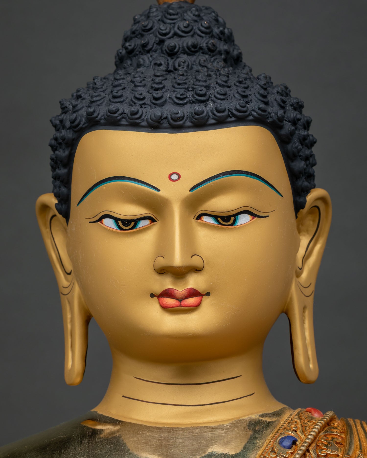 Shakyamuni Buddha statue face close up, serene gold-painted meditative expression