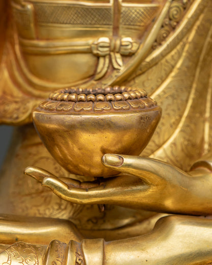 Shakyamuni Buddha statue left hand holding a gold patra bowl, close-up detail