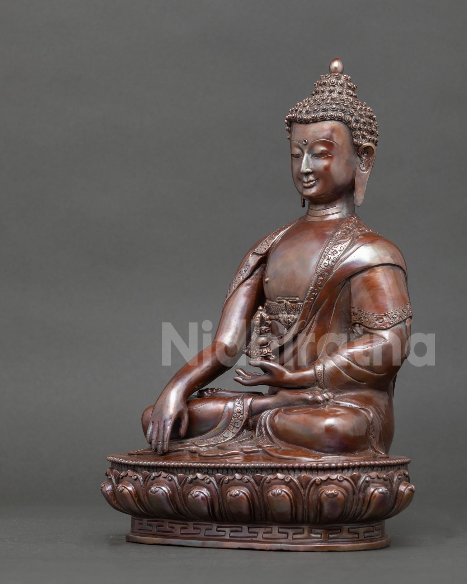 Shakyamuni Buddha statue handcrafted in Nepal using copper and lost wax technique with oxidized finish, seated on a lotus throne in earth touching mudra.