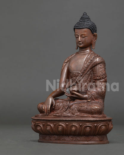 Shakyamuni Buddha statue handcrafted in Nepal using copper and lost wax technique with oxidized finish, seated on a lotus throne in earth touching mudra.