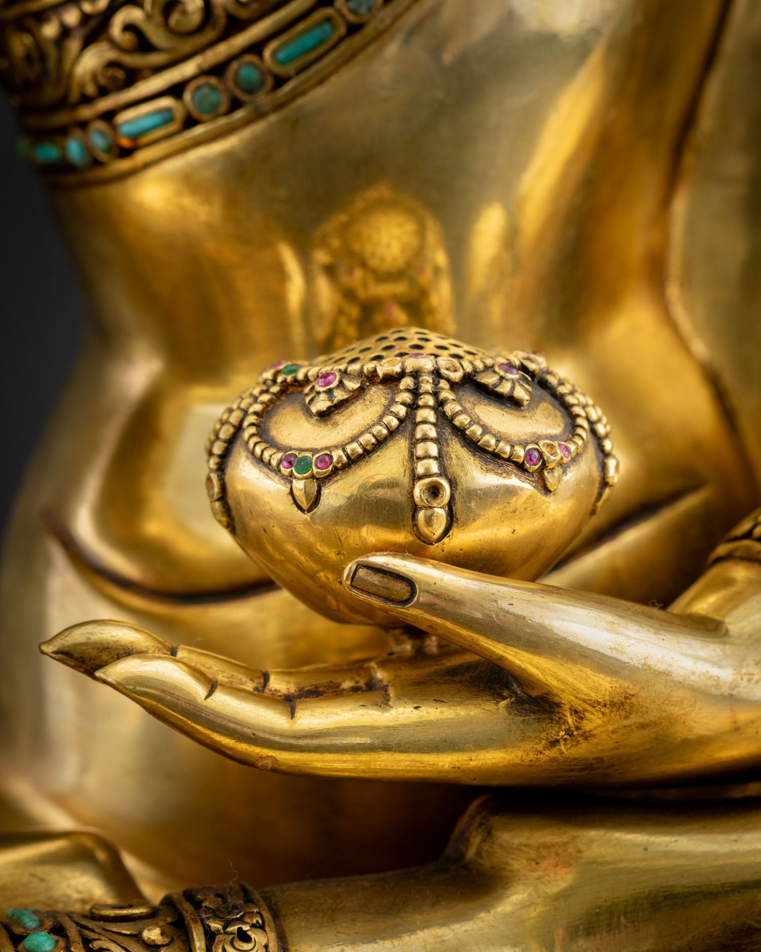 Shakyamuni Buddha statue hands holding alms bowl, detailed 24K gold-gilded close-up