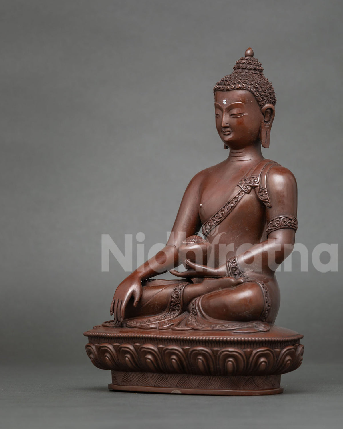 Shakyamuni Buddha statue holding a begging bowl in his left hand.