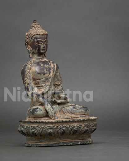 Shakyamuni Buddha statue in earth touching mudra seated on lotus pedestal, oxidized copper