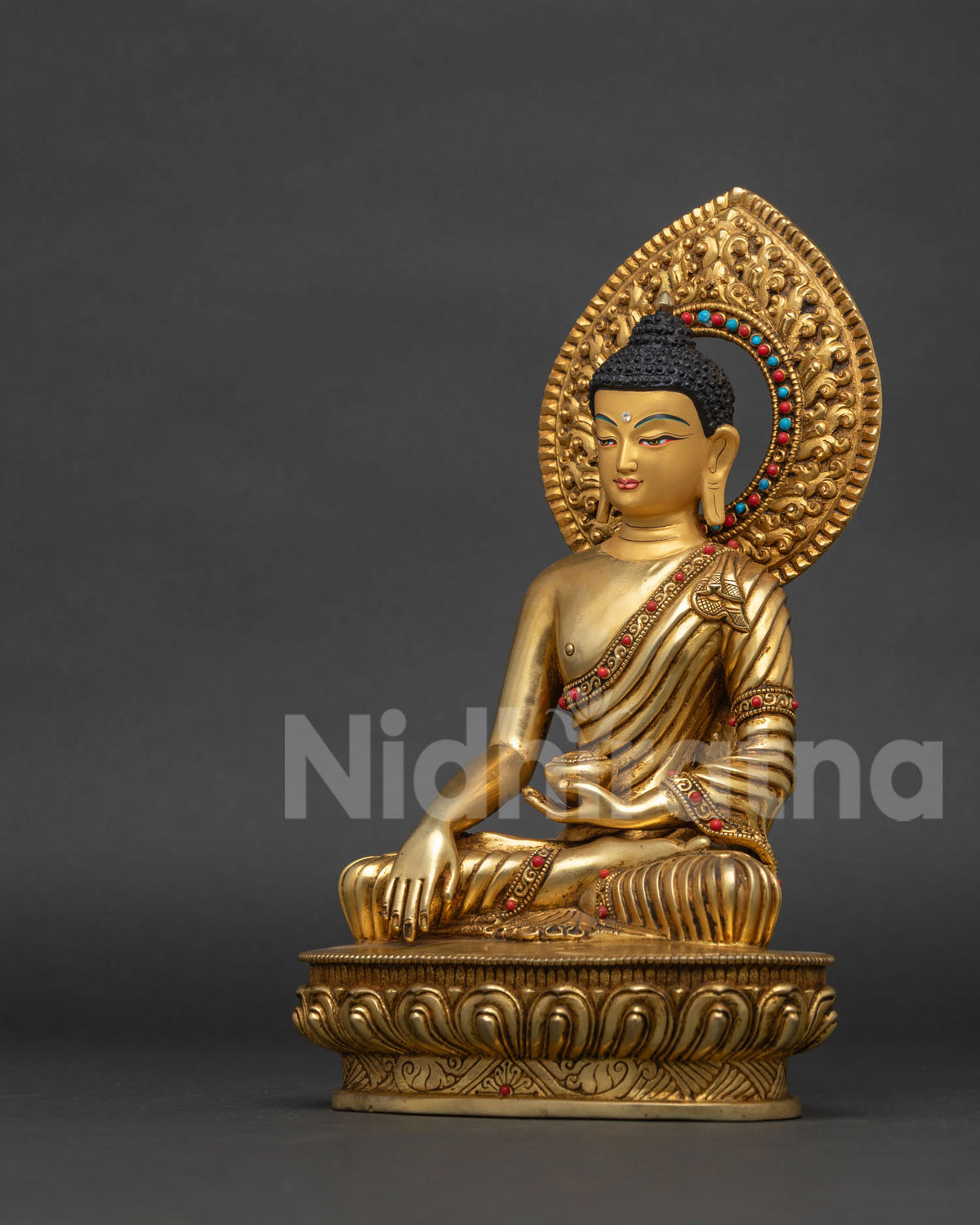 Shakyamuni Buddha statue left side view showing semi precious stone details radiant halo and handcarved lotus base.