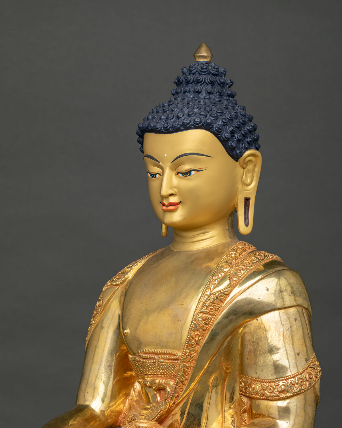 Shakyamuni Buddha statue upper body view with engraved robe borders in fire-gilded copper