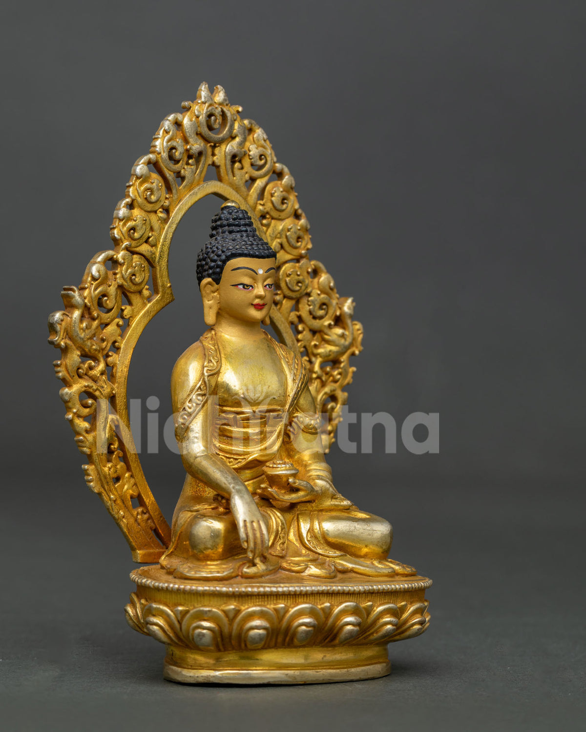 Shakyamuni buddha statue with 24k gold painted face and ornate halo.