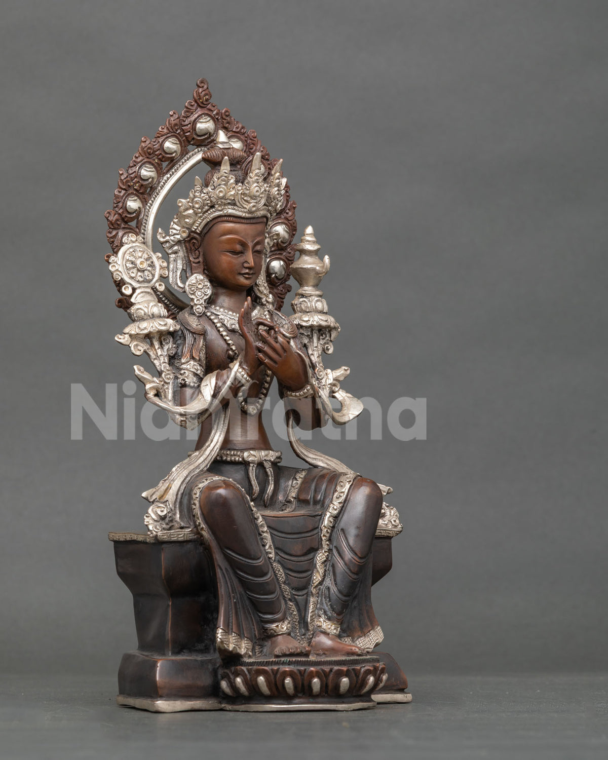 Side angle of handcrafted Maitreya Buddha statue in oxidized copper with ornate halo and silver details