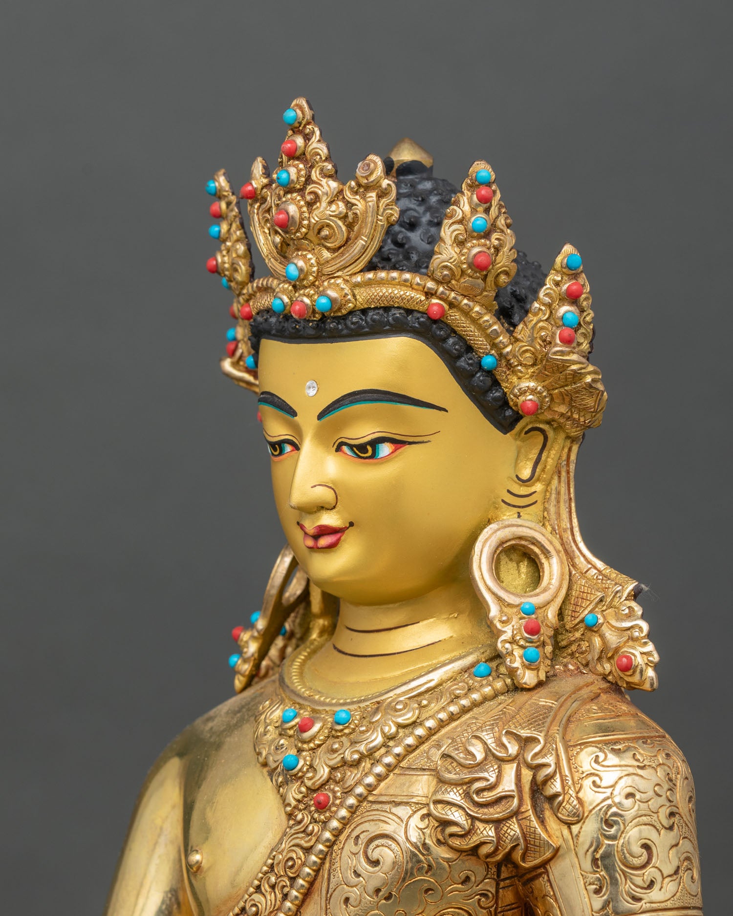 Side close-up of Crowned Shakyamuni Buddha statue, ornate crown and robes in detail