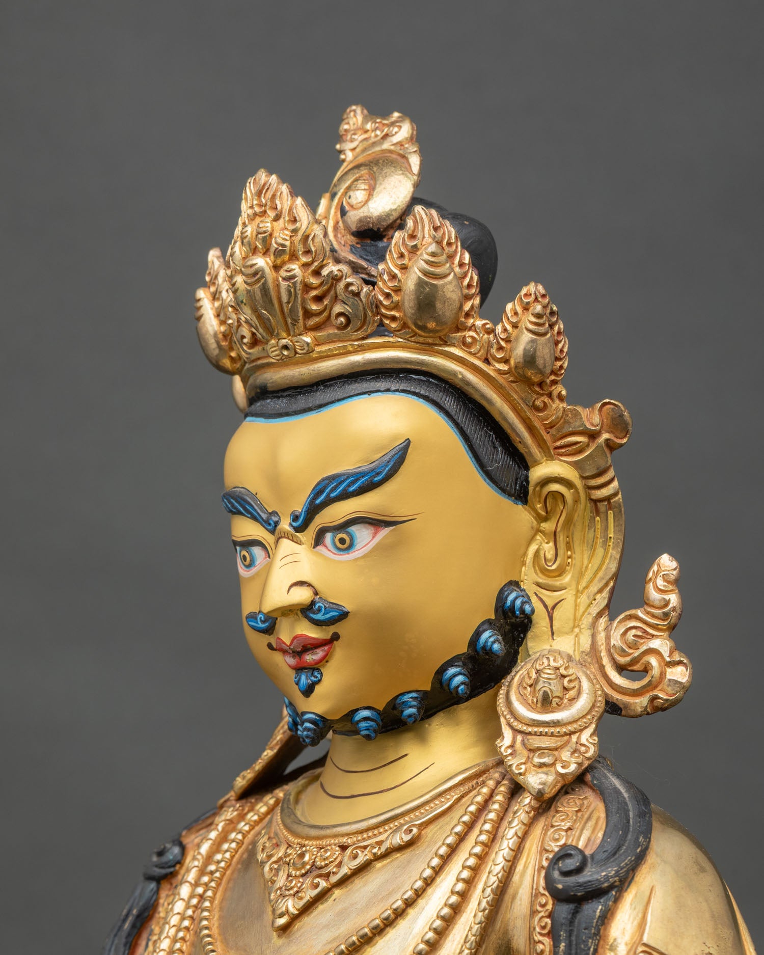 Side close-up of Dzambhala Statue, ornate jewelry and lotus throne, handcrafted Nepalese art